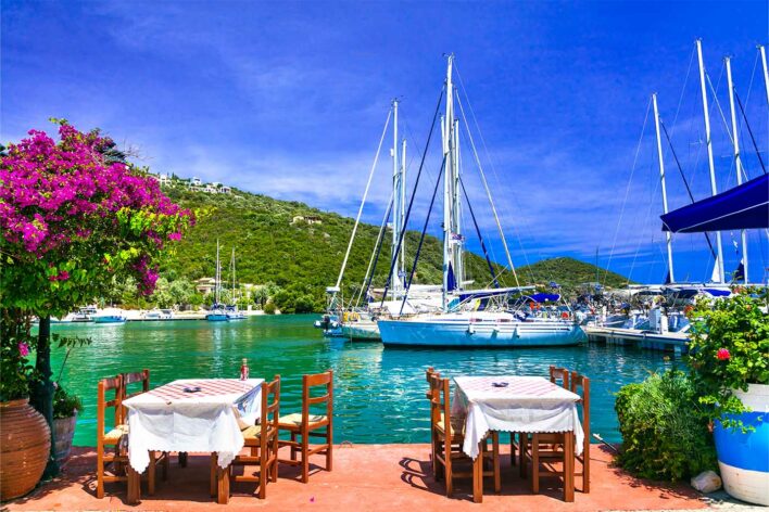 restaurant tables in a marina in Greece with yachts moored up