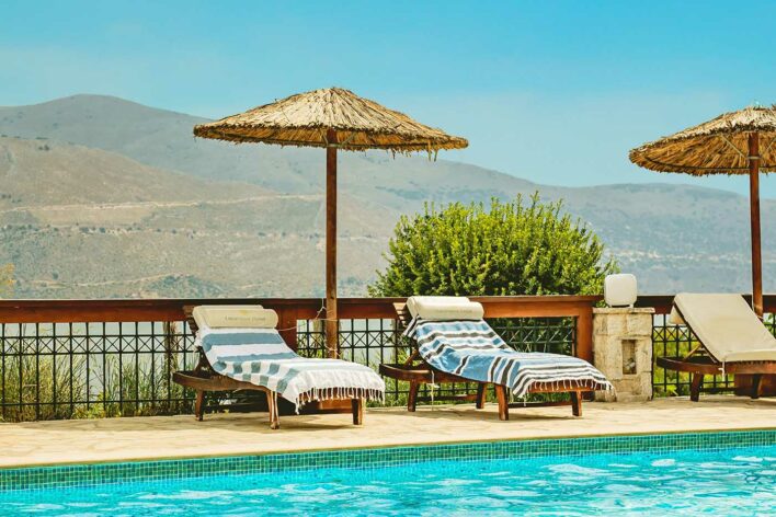 Sun loungers by the pool with hillside backdrop