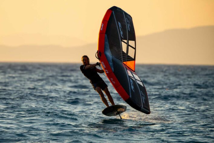 A man wingfoiling in the sunset