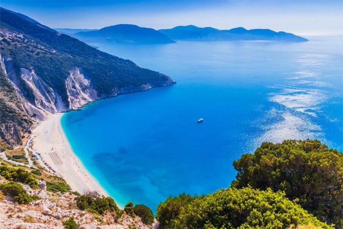 View looking down over a sandy beach and bay in Kefalonia, Greece