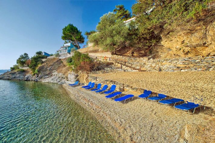 Blue sun loungers on shingle beach with hotel behind