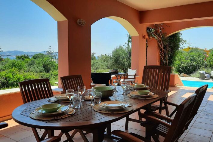 Laid up wooden table up villa veranda with sea views