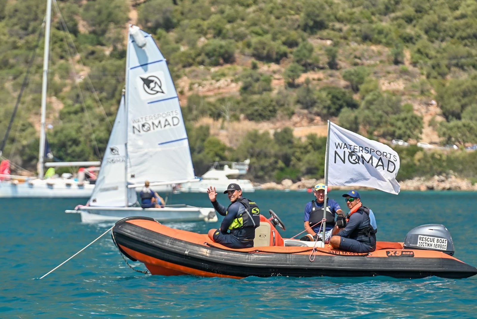 Sailing instructors watching a student race from a powerboat in Greece