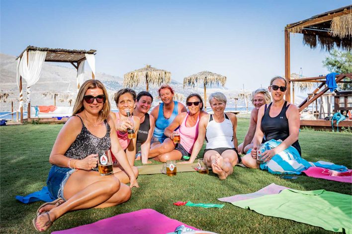 group of friends enjoying cold drinks after a day of water sports and yoga