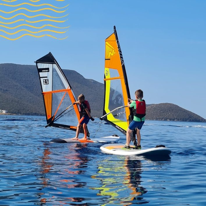 Two young boys learning to windsurf on an RYA Stage 1 windsurf course in Lixouri Bay, Kefalonia, Greece
