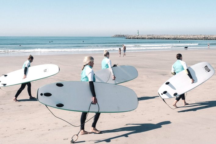 A group of beginner surfers have a lesson at a beach club in Portugal