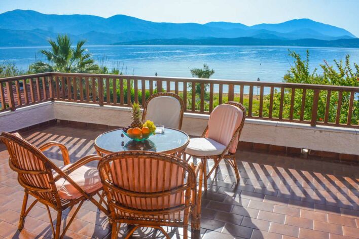 Large balcony with table and chairs with gorgeous sea and mountain view